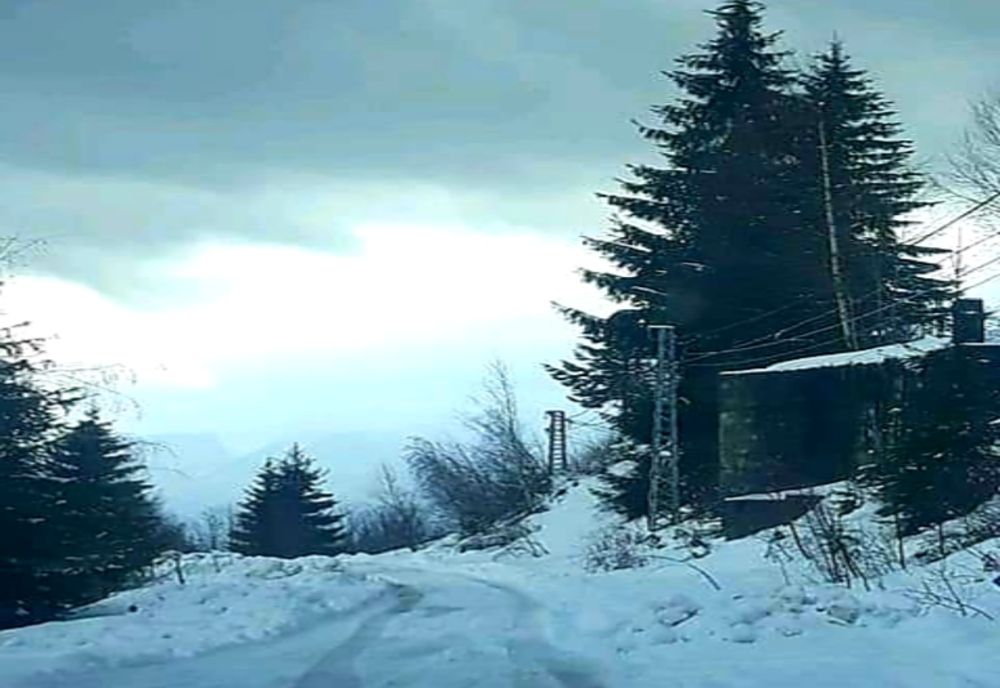 Turiști surprinsi de stratul de zăpadă și apele ieșite din matcă pe un drum neasfaltat